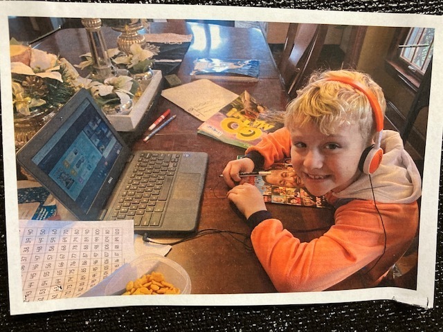 A happy student with headphones during remote learning