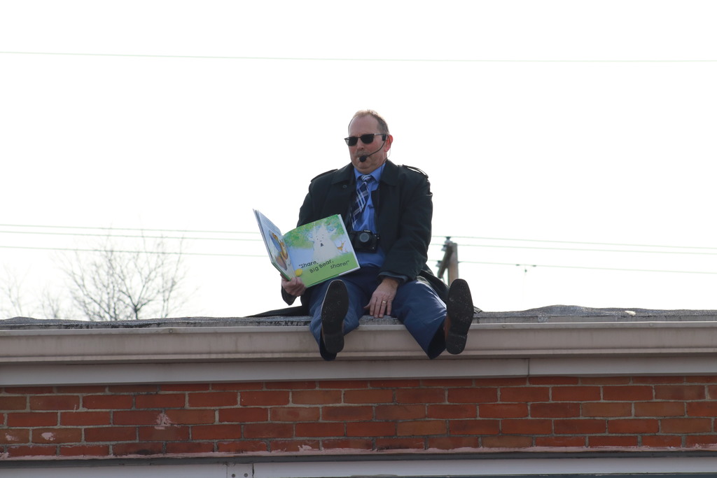 Mr. G. reading a book from the school's roof.