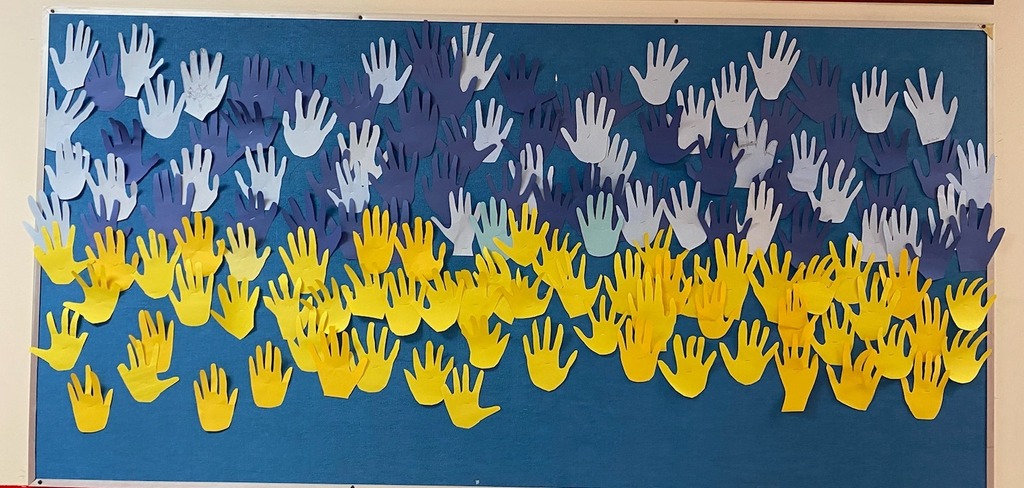 Paper hands on a bulletin board to show support for the innocent people affected by Russia's attack
