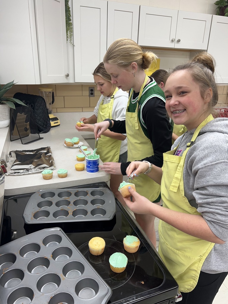 A TMS students smiles while decorating her cupcake.