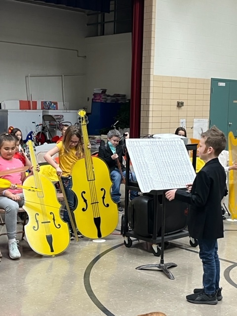 A student serves as the conductor for the orchestra.