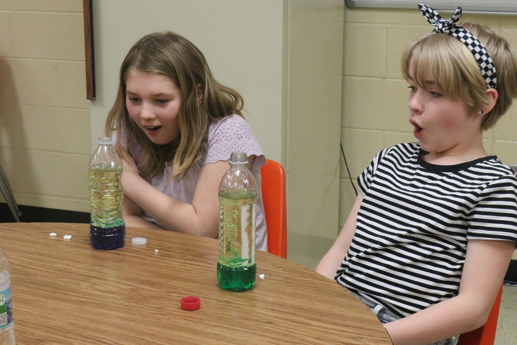 Two girls are amazed at their science experiment results.