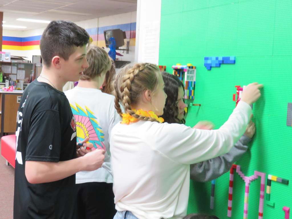 Students have fun while working collaborative to create on the Lego Wall