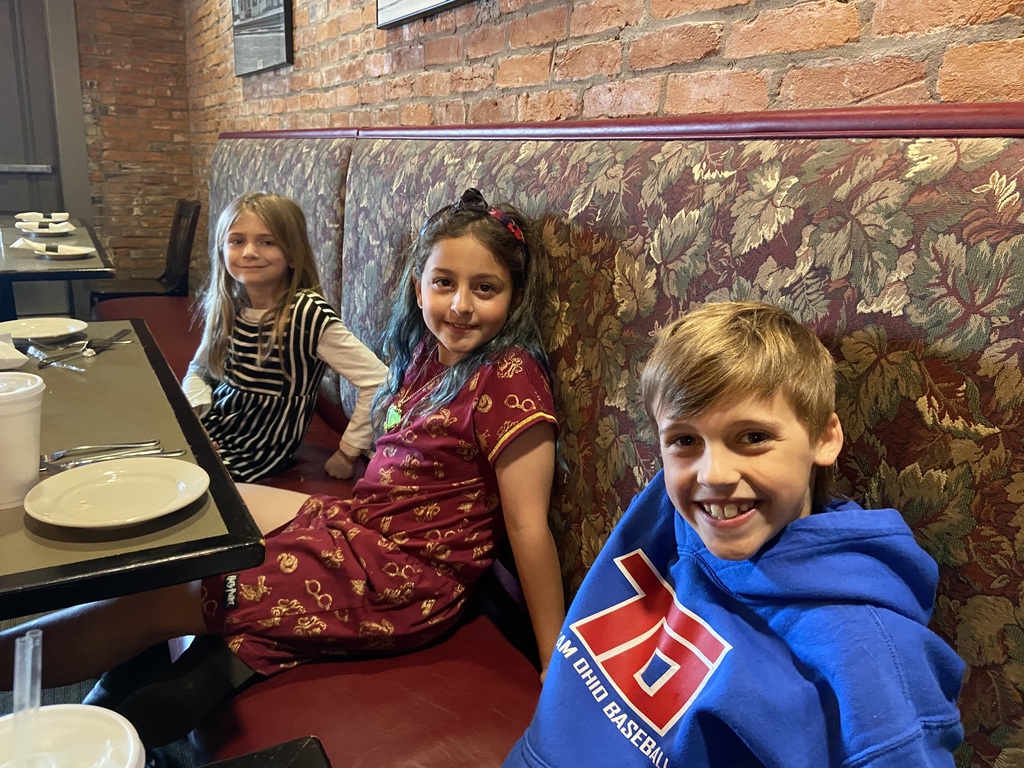 Three Broadway Elementary students enjoy lunch at a restaurant.