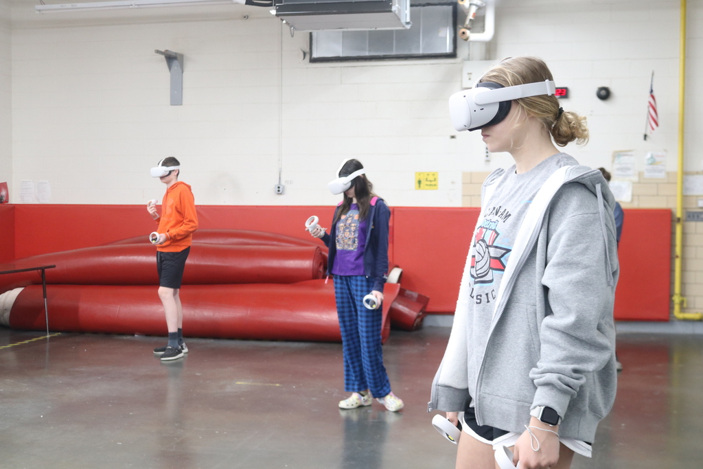 Three students look through their VR goggles.