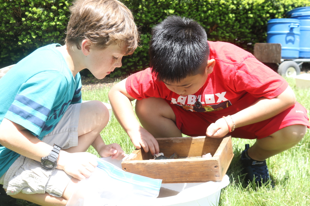 Students compare their gems from mining with "The Rock Man."