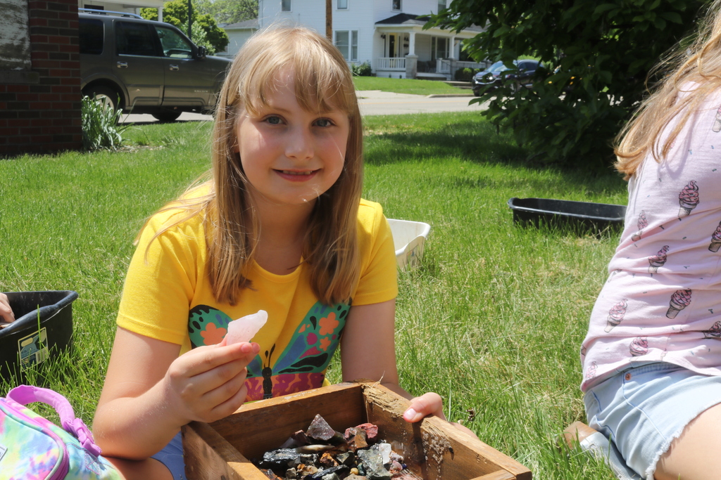 A 3rd grader shows off her rocks that she found while mining.
