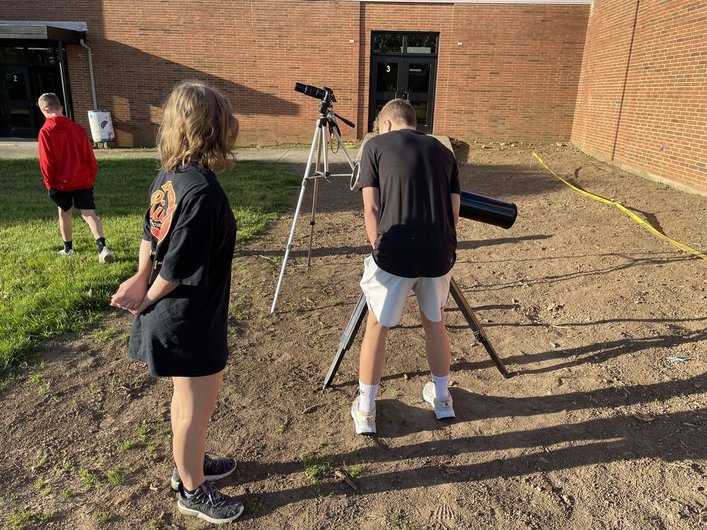 Students look through a telescope.
