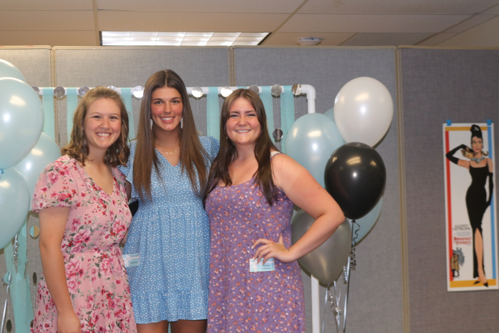 Three Class of 2022 friends smile for a picture at the  senior girls tea hosted by Community Minded Women.