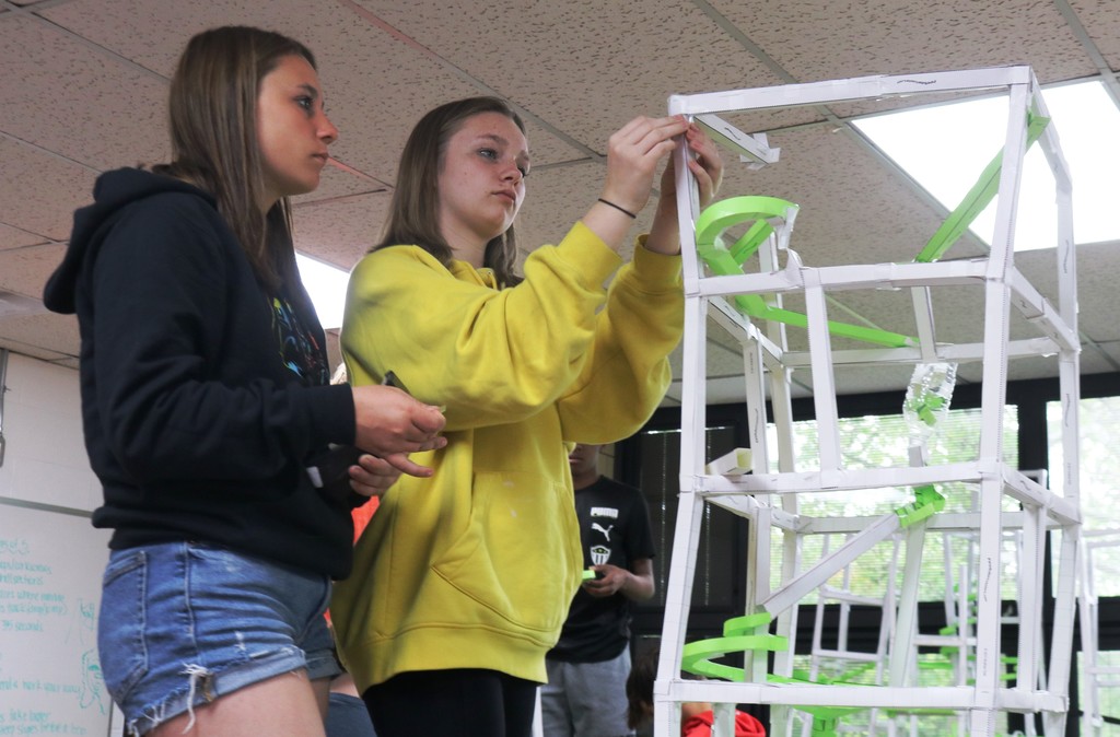 Two TMs students work on building their roller coaster.