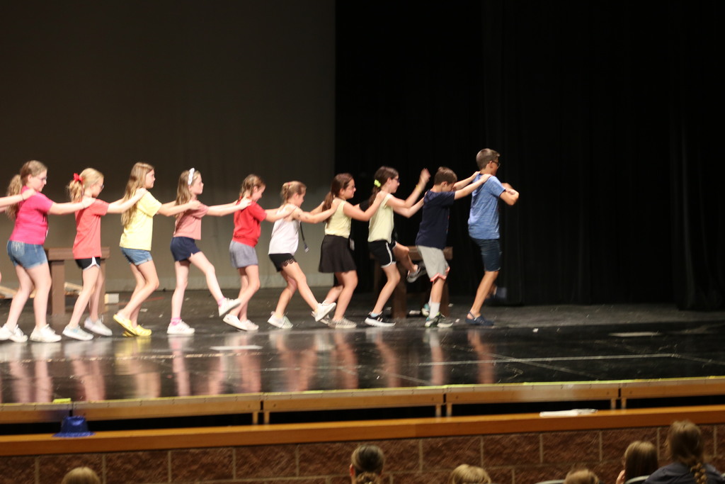 Young performers rehearse a dance move.