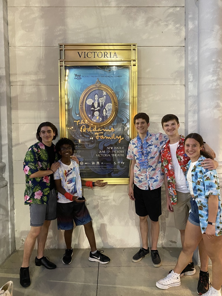 Five students stand in front of a sign at Victoria Theatre.