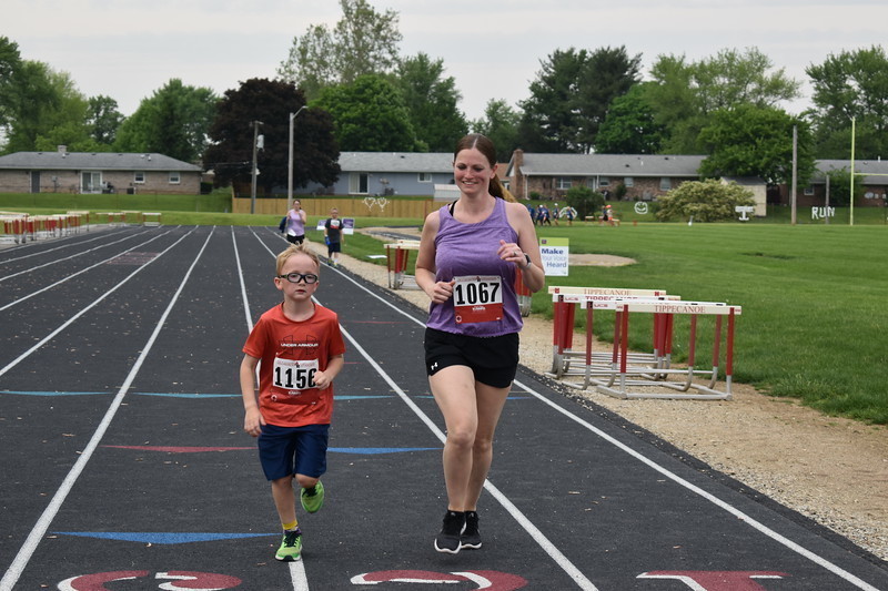An adult and child run together during the Relay for Life