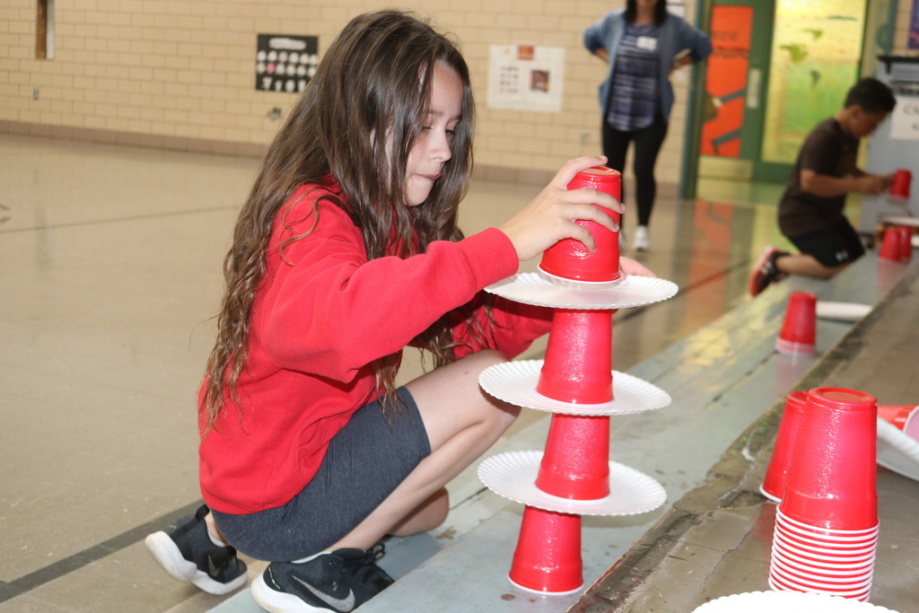 A girl stacks cups during field day.