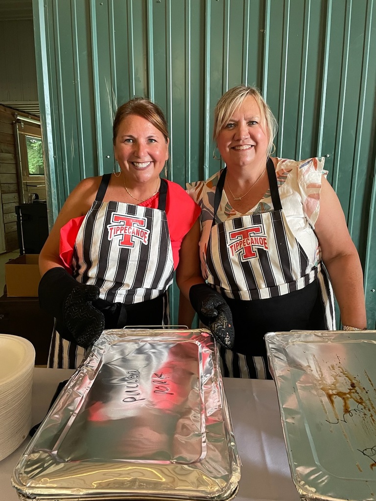 Two staff members wear their Tipp aprons while helping at a family member's wedding.