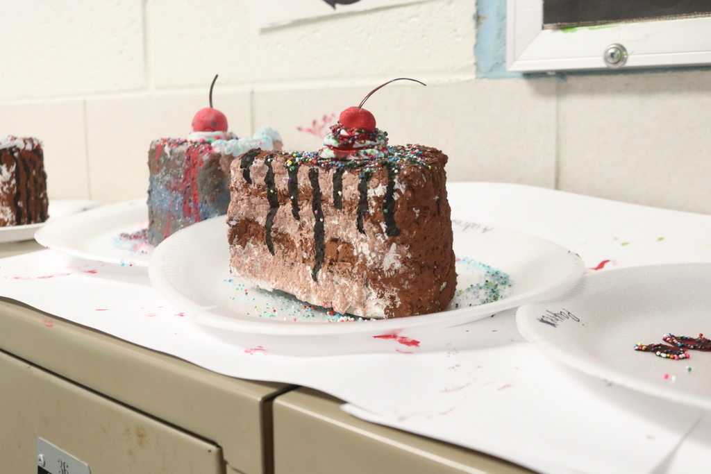 A three-tiered piece of chocolate cake created by a little artist.