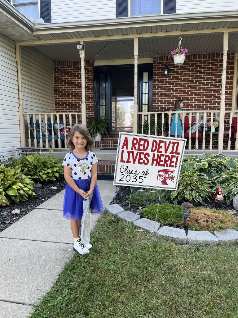 A little girl poses with her yard sign.