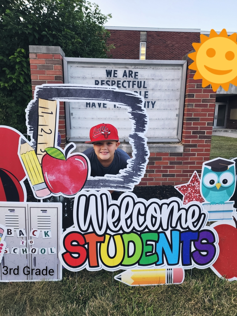 A student poses in the Welcome Students sign.