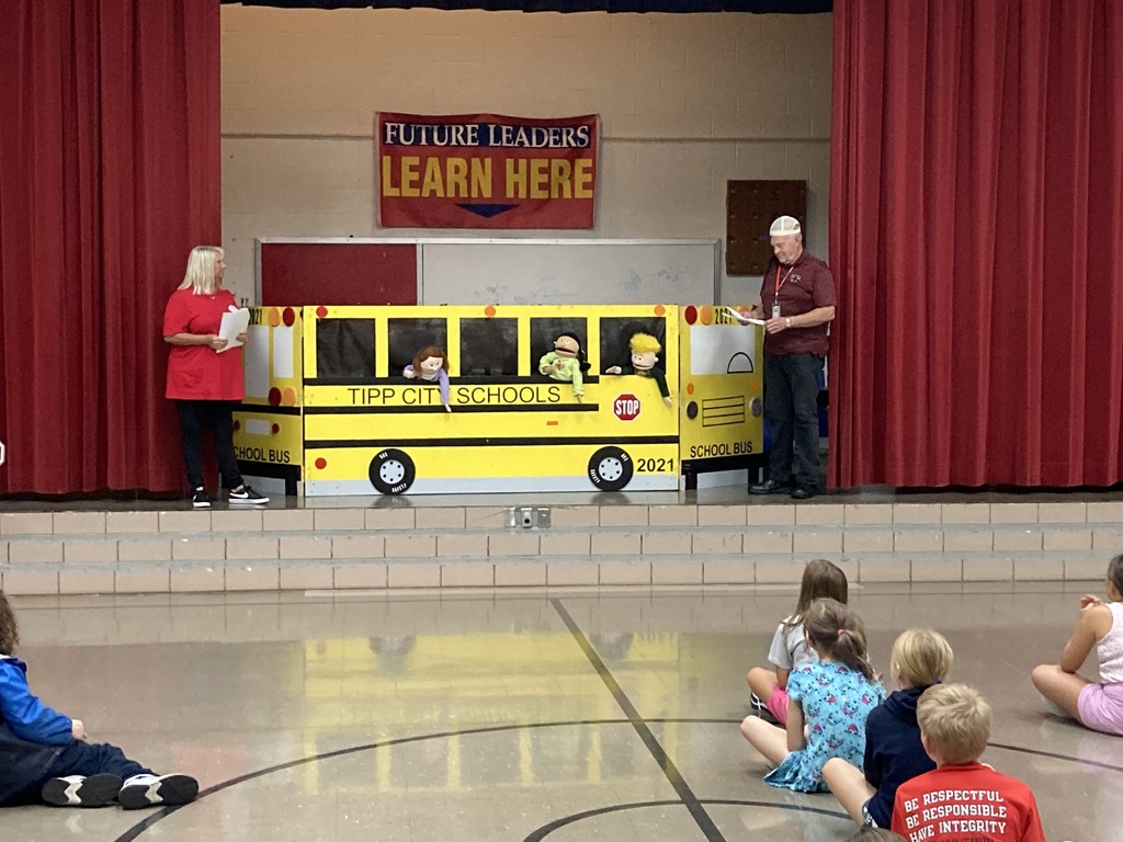 Students listen to bus drivers talk about bus safety.