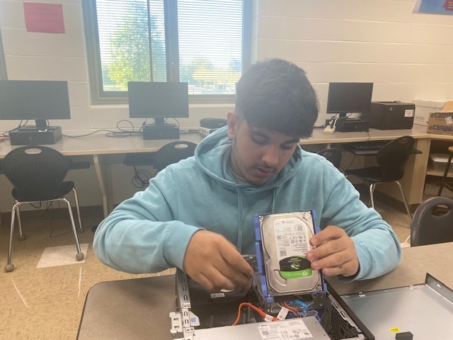 THS students works to take apart a computer.