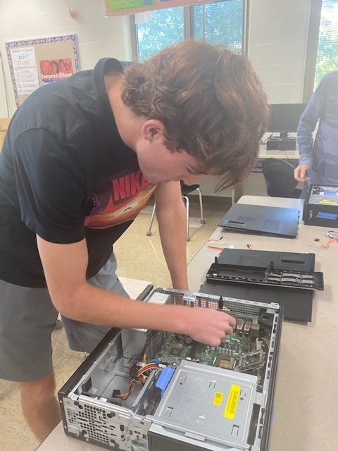 Student takes a computer apart.