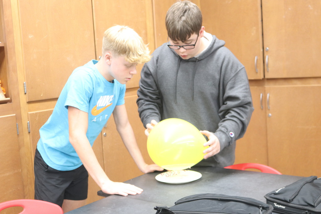 Students work with a balloon during science lab.