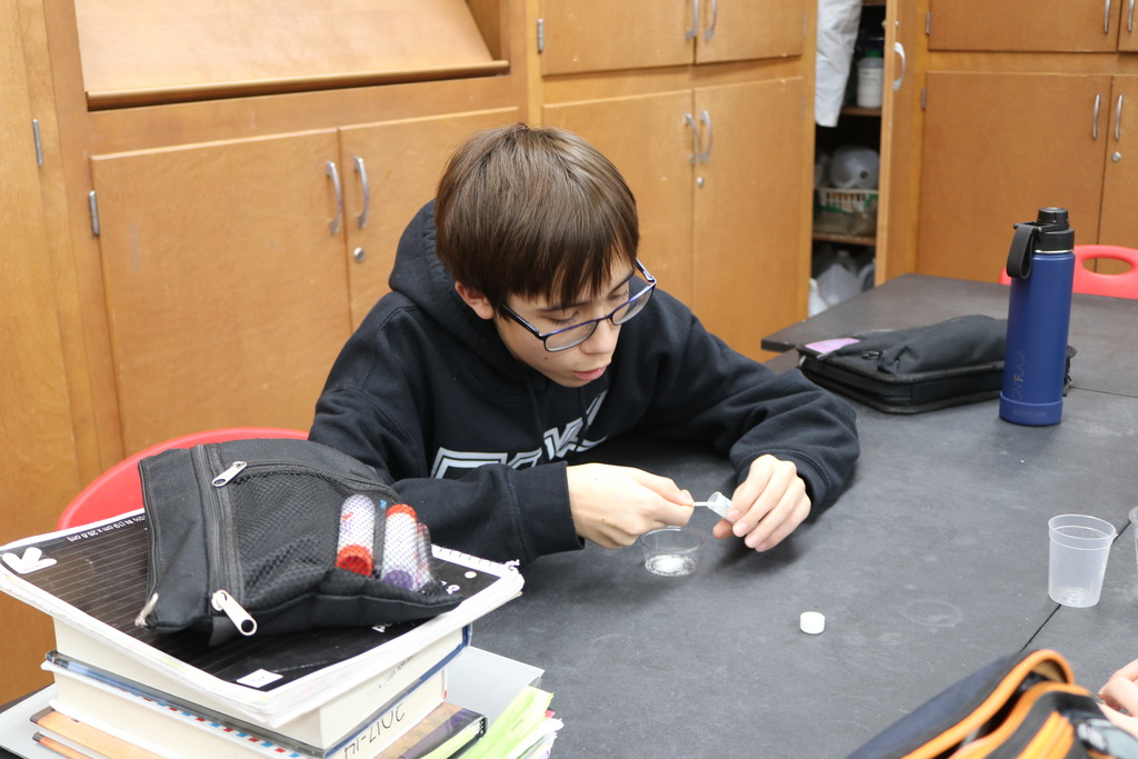 Student measures out material for science project.