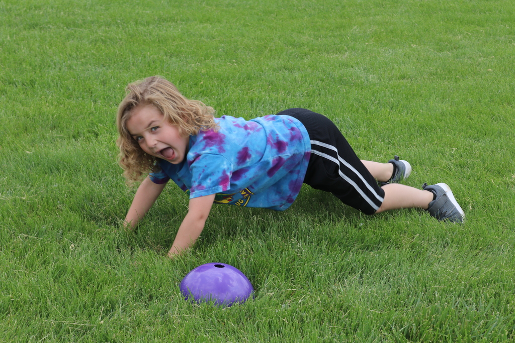 A boy stays in the plank position at field day.