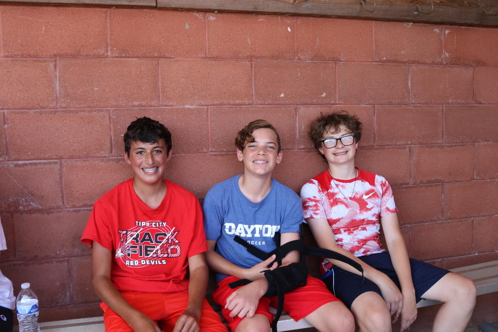 Three TMS students take a break in the dugout.