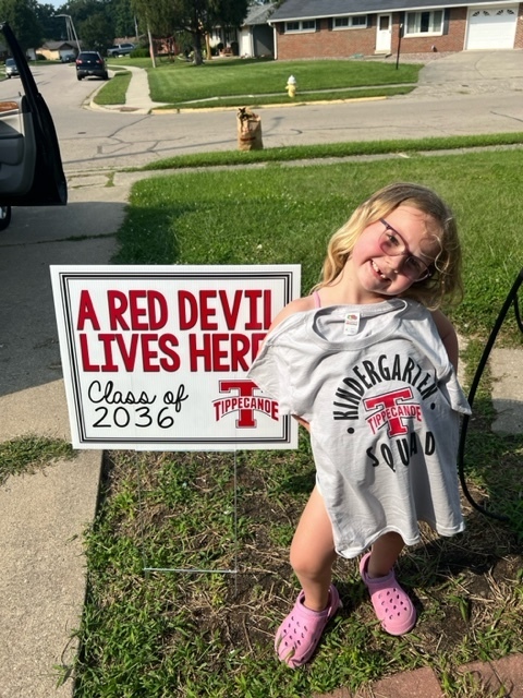 Incoming kindergarten students with his new shirt and sign.