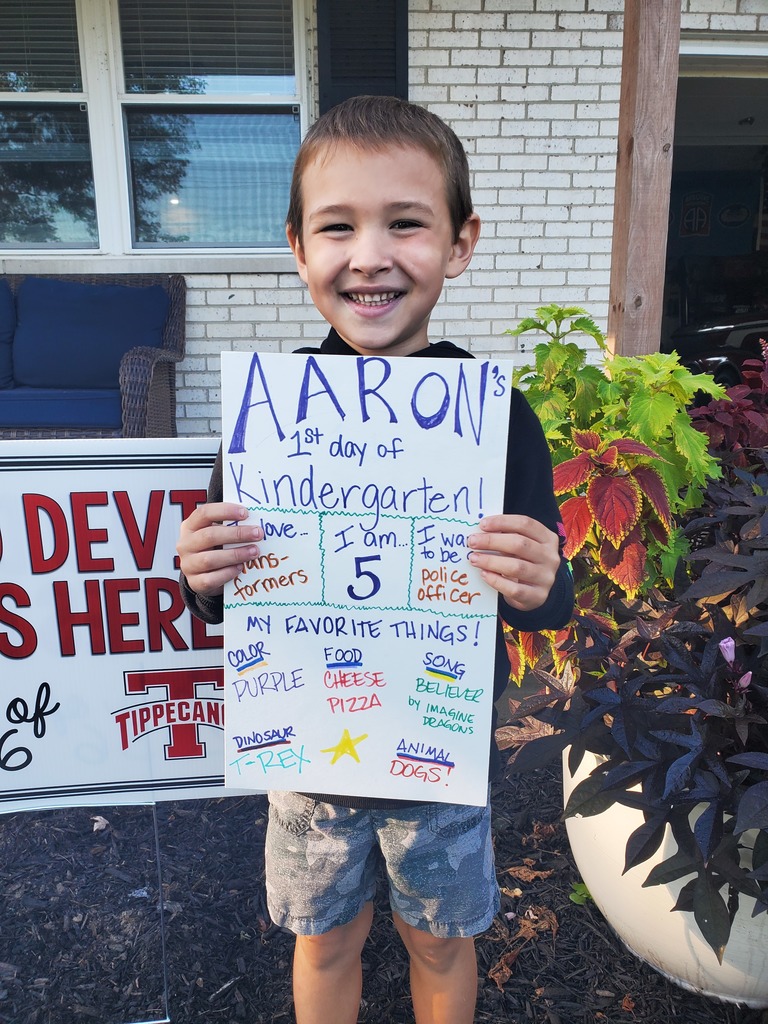 A young student poses for a first-day photo.