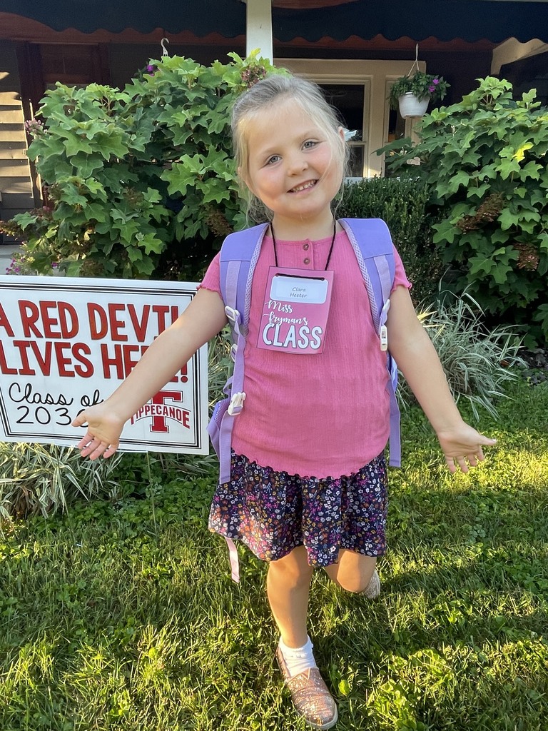 A young student poses for a first-day photo.