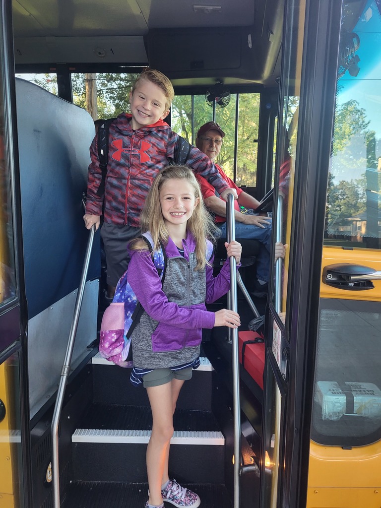 Two students get on the bus for the start of a new school year.