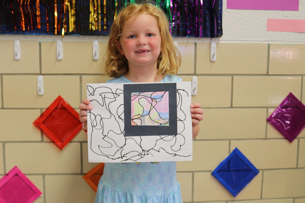 A student holds her artwork.
