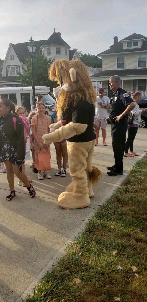 Daren the Lion greets students in the morning.